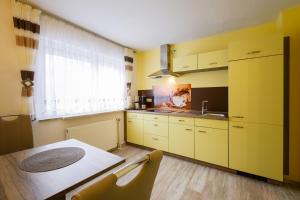 普罗布斯特采拉Boxis Ferienhaus的厨房配有黄色橱柜、桌子和窗户
