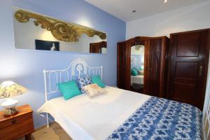 阿尔布费拉Casa Rocha的一间蓝色和白色的卧室,配有一张床和镜子