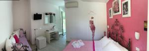 努马纳Giglio Del Conero的粉红色的卧室,配有一张床和粉红色的墙壁