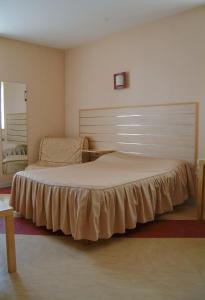 巴勒迪克贝尔特兰德酒店的一间卧室配有一张带大床头板的床