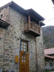 埃斯皮纳马Casa Rural La Torre de Espinama的石头建筑,设有木门和阳台