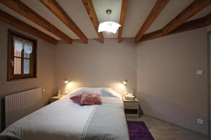 沃洛格河畔格朗热莱斯占姆奥克斯住宿加早餐旅馆的一间带一张大床的卧室,位于一个拥有木制天花板的房间
