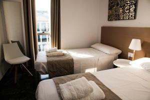 科尔多瓦Wallada Centro的酒店客房设有三张床和窗户。