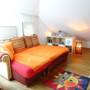 博登斯边的伊门施塔特Wohlfühlhaus Immenstaad的一间卧室配有一张带橙色床罩的床
