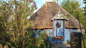 翁弗勒尔Aux murmures de la nature的茅草屋顶的房子,有蓝色的门