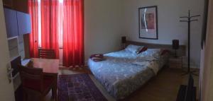 布鲁塞尔梅森德拉蜜月公寓式酒店-代埃尔泰贝克 小型酒店的一间卧室配有一张床、一张桌子和红色窗帘