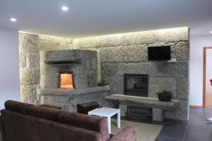 维埃拉·多米尼奥Casa do Sobreira的客厅设有带壁炉的石墙