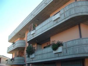 佩斯卡拉欧西住宿加早餐旅馆的一座带阳台的建筑,上面有盆栽植物