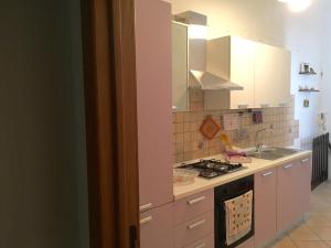 马蒂诺Casa nel Salento da Grace的厨房配有白色橱柜和炉灶烤箱。