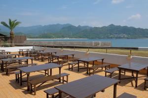 那智胜浦町胜浦日出日式旅馆的水边甲板上的一排桌子和长椅