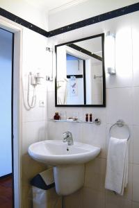 卡尔卡维洛斯Carcavelos Beach Hotel的一间带水槽和镜子的浴室