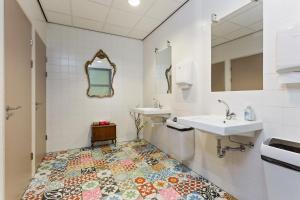 阿姆斯特丹Hostelle - women only hostel Amsterdam的浴室设有2个水槽和马赛克地板。
