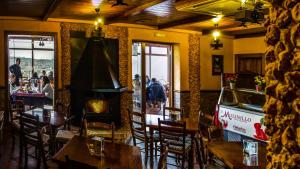 Arenas del ReyComplejo Rural El Molinillo的一间带桌椅和壁炉的餐厅