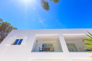 米乔尔海滩Pinos Playa Suites的享有白色房屋的景致,设有2扇窗户。