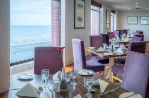 布莱克浦布莱克浦大酒店的一间设有桌椅的海景餐厅