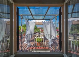 比萨7间房住宿加早餐旅馆的窗户享有带椅子的阳台的景致。