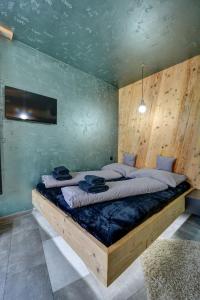 顺佩尔克爱丽莎公寓的一间卧室设有一张带木墙的大床