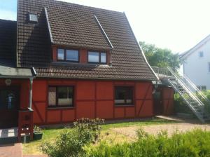 普雷罗ton Timmermanns Hus的一间红色的房子,有金属屋顶
