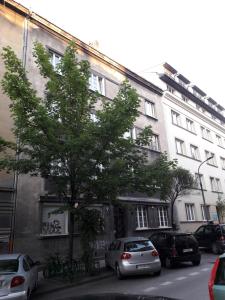 克拉科夫Cichy apartament w centrum Krakowa Salwator的一座白色的大建筑,前面有汽车停放