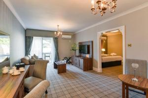 罗奇代尔曼彻斯特诺顿格兰治Spa美居酒店的带沙发、床和桌子的客厅