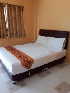 桑卡武里桑卡拉布里察纳卡尔恩宾馆的一间卧室配有一张大床和木制床头板