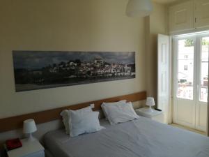 康斯坦西亚Casa João Chagas Guesthouse, Constância的卧室配有一张床,墙上挂有绘画作品