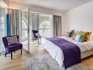 卢塞恩卢塞恩安克尔酒店的一间卧室配有一张大床和一张紫色椅子
