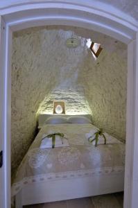 阿尔贝罗贝洛Suite Curcuma的一间小卧室,配有一张石墙床