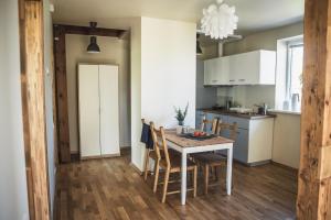 拉脱维亚Krauklis beach apartments的厨房以及带桌椅的用餐室。