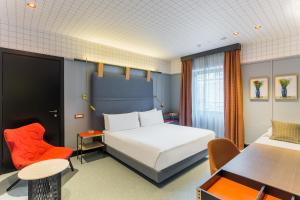 米兰马特朱利亚酒店的酒店客房,配有一张床、一张桌子和椅子
