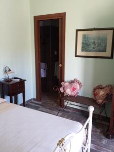 比亚恩科Agriturismo Donna Beatrice的卧室配有1张床、1张桌子和1把椅子