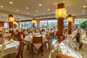 埃斯塔蒂特全景酒店的餐厅设有白色的桌椅和窗户。