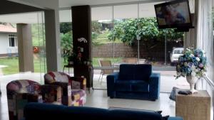DescansoHotel Descanso的客厅配有椅子、电视和桌子