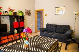 巴塞罗那若斯雷欧尼公寓的客厅配有沙发和鲜花桌