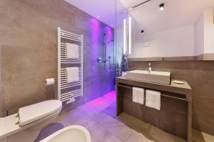 彼得斯堡加斯索夫韦伯酒店的浴室设有卫生间和带紫色灯的盥洗盆。
