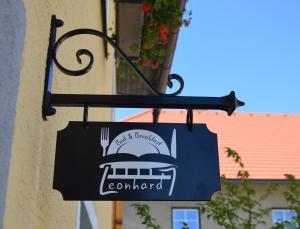 阿诺尔德施泰因B&B Leonhard 7的挂在建筑物一边的餐厅标志
