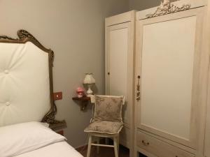 马里纳迪马萨Ancora bilocale的卧室配有一张床和一把椅子,位于门边
