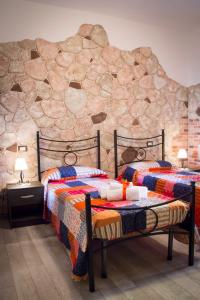 阿尔盖罗Rocca Pinta Guest House的石墙客房的两张床