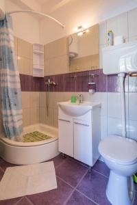 科米扎Apartment Riva 5的浴室配有卫生间、浴缸和水槽。