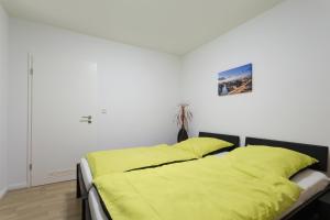 柏林Berlin City Apartments的卧室内的一张黄色床罩