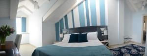 都灵凯撒大帝酒店的一间卧室配有一张蓝色和白色条纹的床