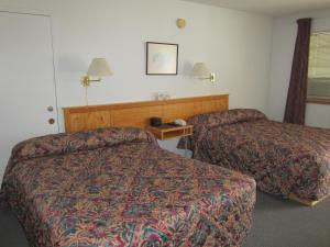 道森市Bonanza Gold Motel的酒店客房设有两张床和一张桌子。