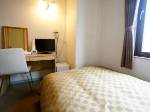 岩国市特伦德岩国酒店的一间卧室配有一张床和一张带电脑的书桌