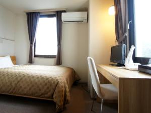 岩国市特伦德岩国酒店的酒店客房配有一张床和一张书桌及一台电视