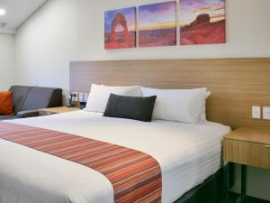 珀斯珀斯舒适乡村公寓式酒店的酒店客房带一张大床,带白色床单