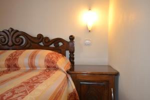 索佐波尔Family Hotel More的一间卧室配有一张床和一个床头,墙上有灯。