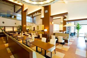 Miki神户雀巢度假酒店的配有木桌和白色椅子的餐厅