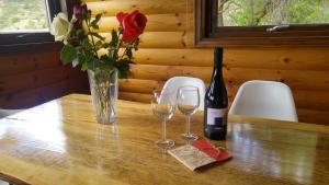 KhandriaVasiliou House Krimenos的一张桌子,上面放着两杯酒和一瓶葡萄酒