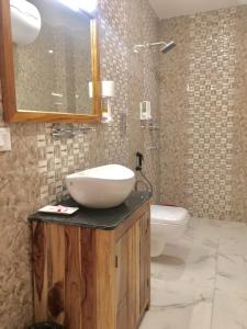 帕罗Hotel Khamsum的一间带水槽、卫生间和镜子的浴室