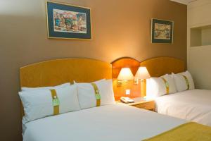 布拉瓦约Holiday Inn - Bulawayo, an IHG Hotel的酒店客房设有两张床和电话
